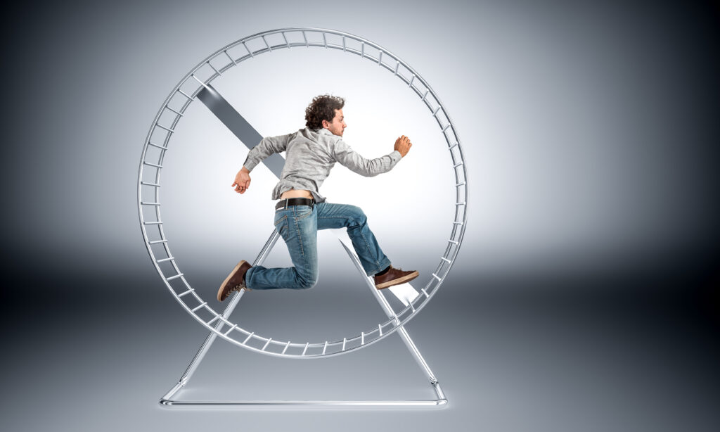 Man running in a huge hamster wheel, going nowhere